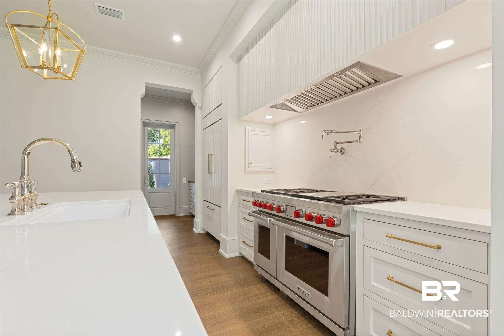 3 Canterbury Park Mobile, AL 36608 - Photo 6 of 43 Kitchen featuring range with two ovens, a sink, ornamental molding, wood finished floors, and light countertops