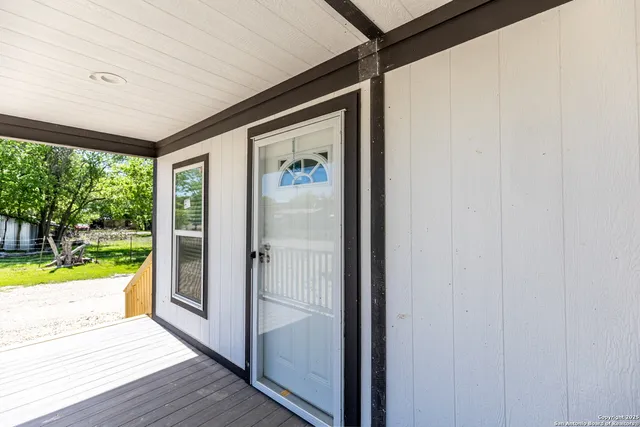a view of a porch with wooden floor and front door