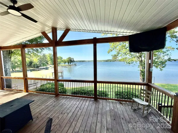 a view of deck with wooden floor and fence next to a yard
