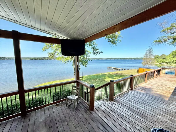 a view of a lake with a big yard and large trees