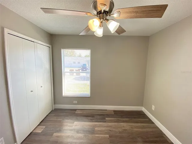 an empty room with windows and fan