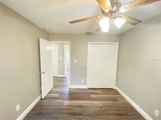 a view of a hallway with wooden floor and chandelier