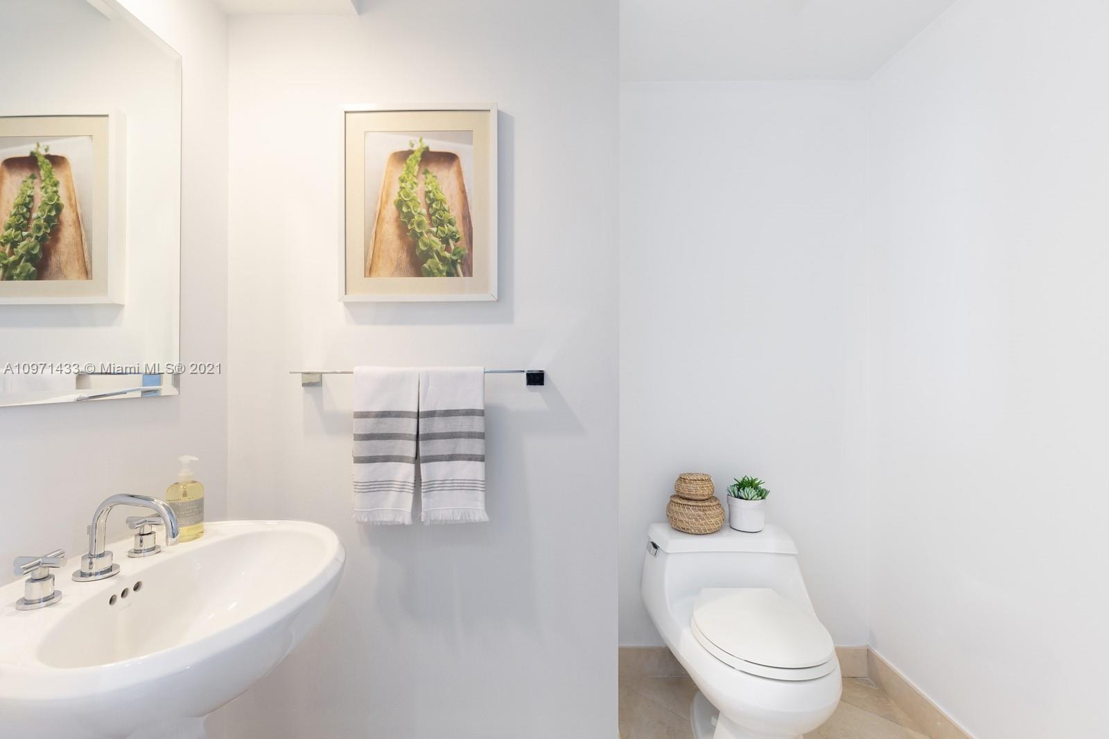 848 Brickell Key Drive, Unit 904 Miami, FL 33131 - Photo 12 of 31 a bathroom with a toilet a sink and mirror