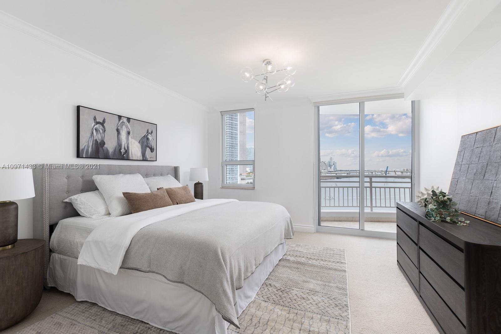 848 Brickell Key Drive, Unit 904 Miami, FL 33131 - Photo 13 of 31 a spacious bedroom with a large bed and a chandelier