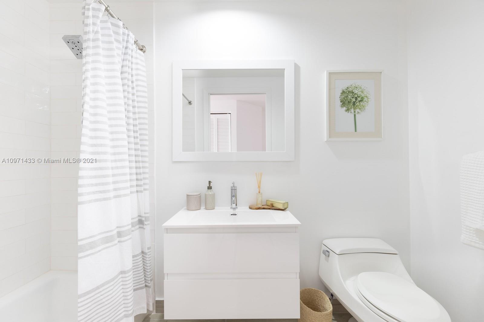 848 Brickell Key Drive, Unit 904 Miami, FL 33131 - Photo 17 of 31 a bathroom with a toilet a sink and mirror