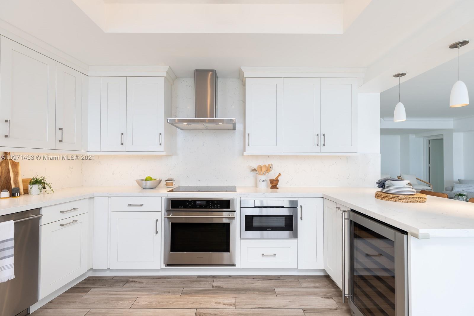 848 Brickell Key Drive, Unit 904 Miami, FL 33131 - Photo 5 of 31 a kitchen with stainless steel appliances granite countertop a sink stove and white cabinets