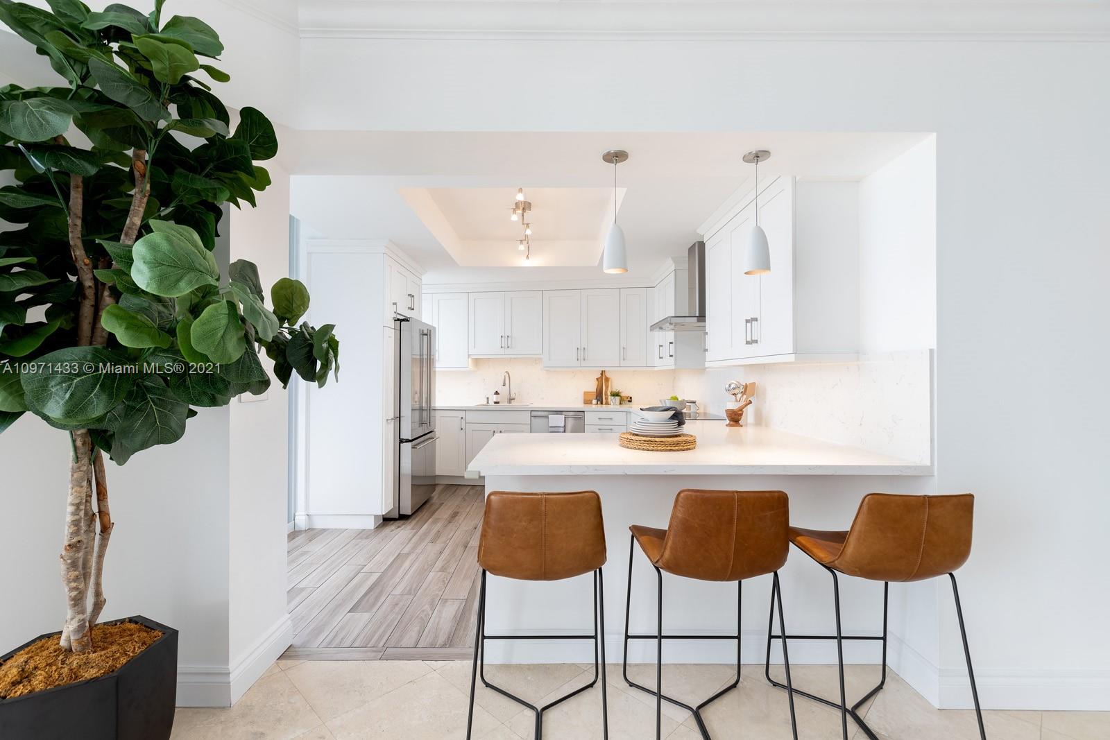 848 Brickell Key Drive, Unit 904 Miami, FL 33131 - Photo 7 of 31 a kitchen with a table and chairs in it