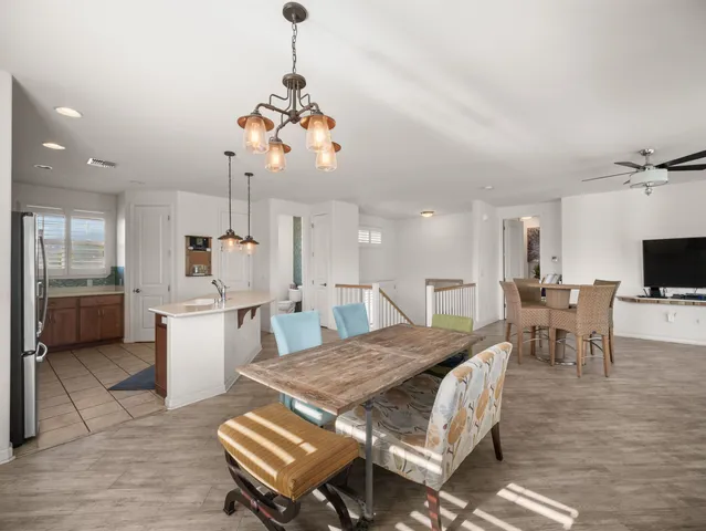 a view of a dining room and livingroom with furniture wooden floor a chandelier