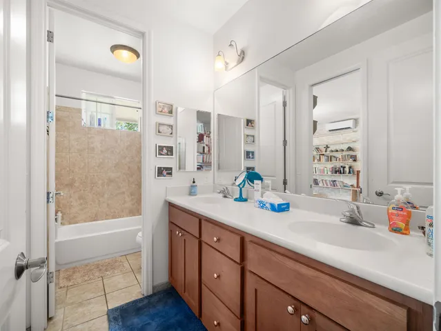 a bathroom with a sink a mirror a bathtub and shower