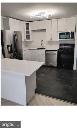 a kitchen with stainless steel appliances kitchen island granite countertop a refrigerator and a stove