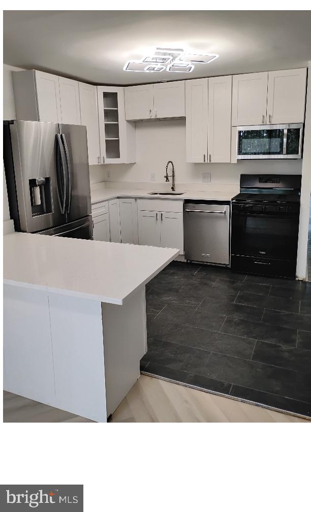 a kitchen with stainless steel appliances kitchen island granite countertop a refrigerator and a stove