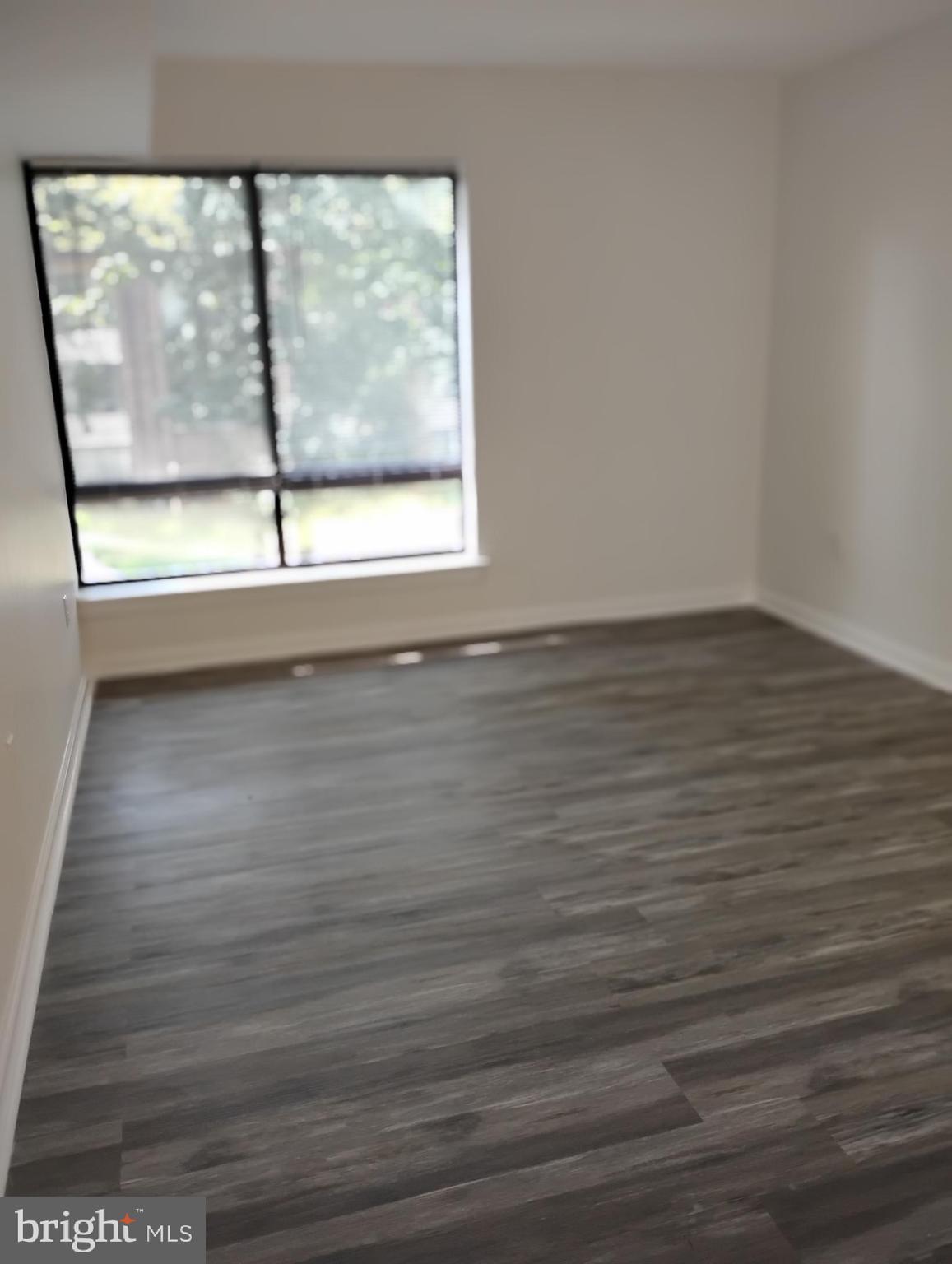 8435 Greenbelt Road, Unit 202 Greenbelt, MD 20770 - Photo 17 of 20 a view of empty room with wooden floor and fan