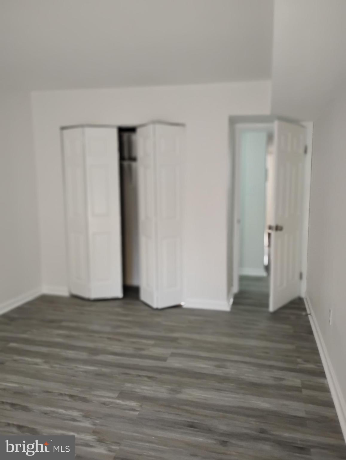 8435 Greenbelt Road, Unit 202 Greenbelt, MD 20770 - Photo 18 of 20 a view of an empty room with wooden floor and a bathroom