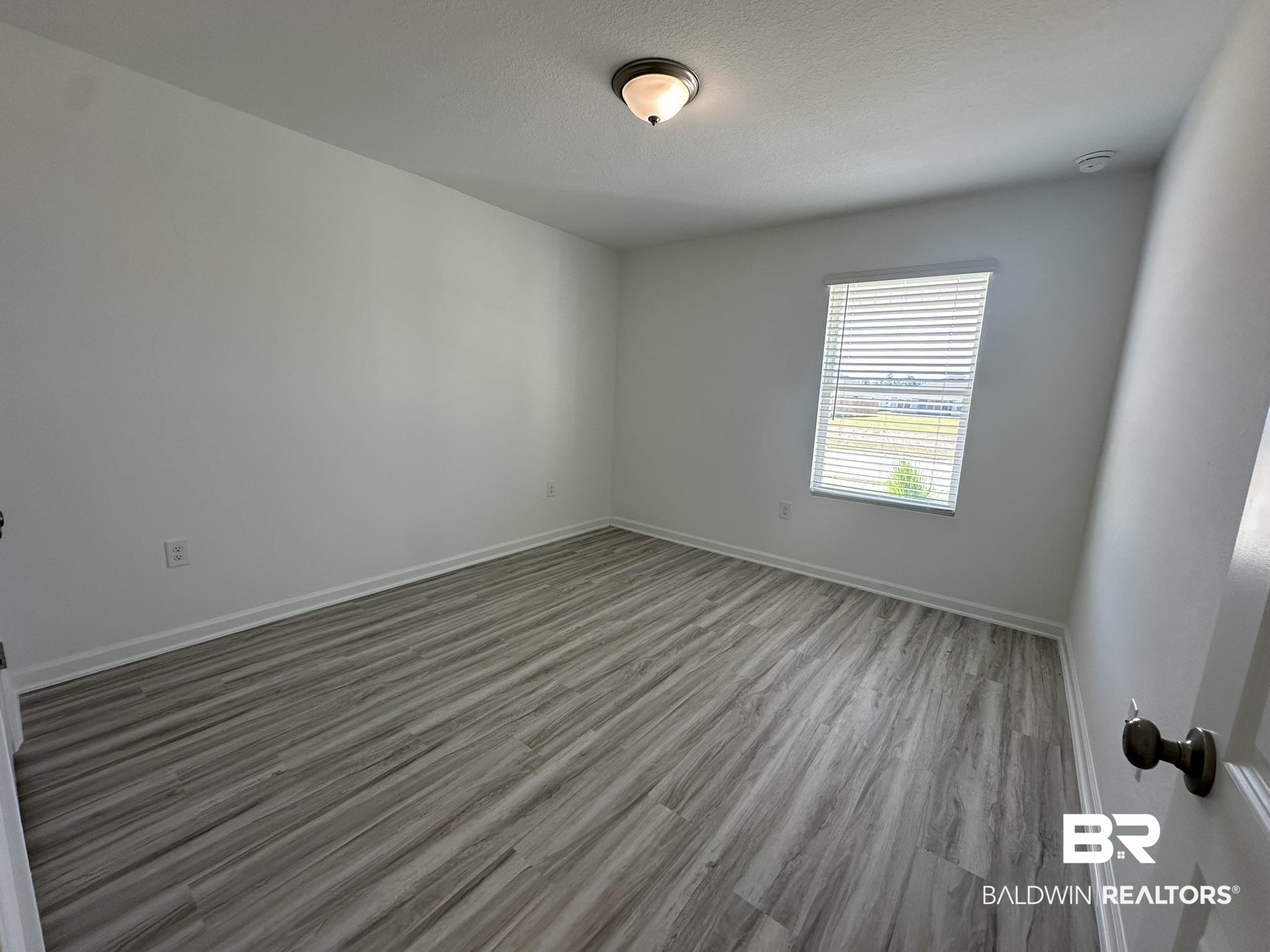 22227 Aleutian Avenue Foley, AL 36535 - Photo 11 of 64 Unfurnished room featuring hardwood / wood-style flooring and a textured ceiling