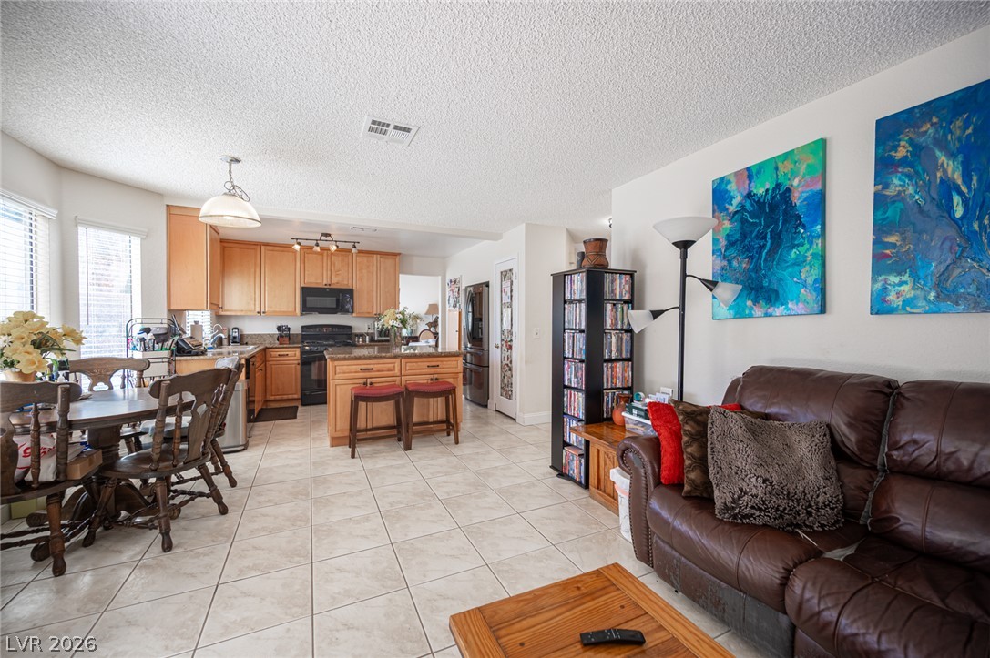 718 Rusty Spur Drive Henderson, NV 89014 - Photo 50 of 50 An open floorplan seamlessly connects the kitchen and living areas, fostering a convivial atmosphere.