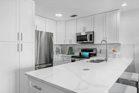 a kitchen with stainless steel appliances sink refrigerator and microwave