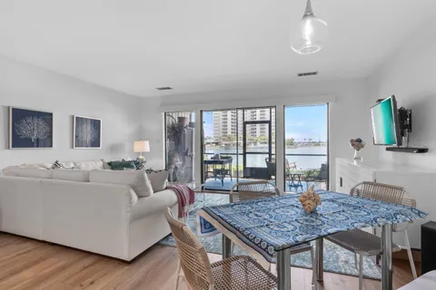 a living room with furniture a flat screen tv and a table