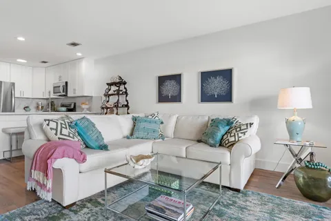 a living room with furniture and a dining table with wooden floor