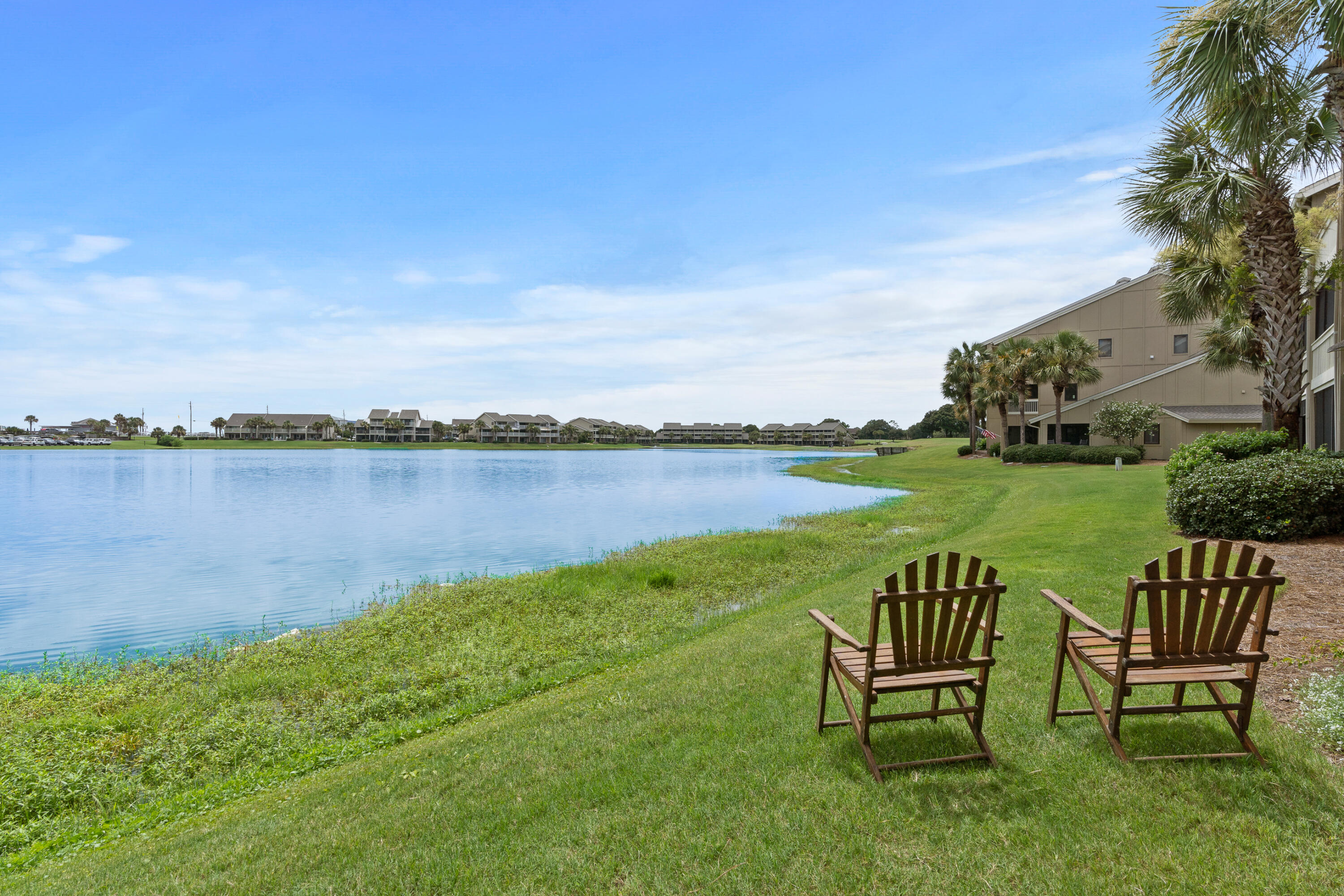 48 Stewart Lake Cove, Unit 194 Miramar Beach, FL 32550 - Photo 41 of 57 a view of a lake with table and chairs next to a yard