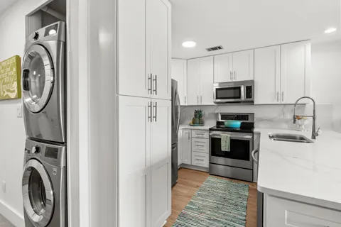 a kitchen with stainless steel appliances granite countertop a refrigerator and a sink