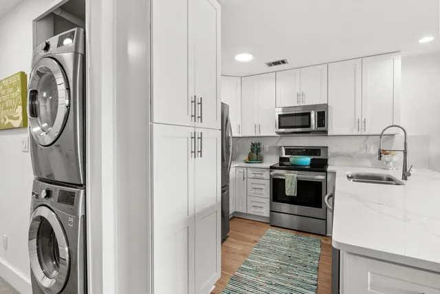 a kitchen with stainless steel appliances granite countertop a refrigerator and a sink