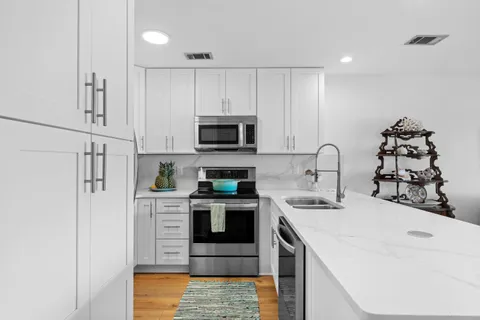 a kitchen with stainless steel appliances a refrigerator sink and microwave