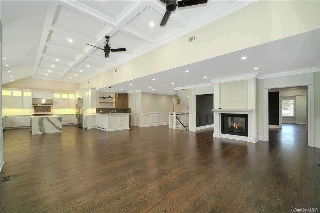 Lot 4 Wading River Road Manorville, NY 11949 - Photo 15 of 28 Unfurnished living room with dark wood-type flooring, coffered ceiling, a multi sided fireplace, ceiling fan, and beam ceiling. FOR MARKETING PURPOSES ONLY!