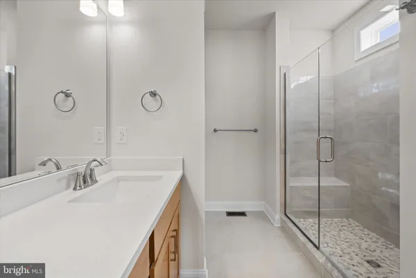 a bathroom with a shower sink vanity and mirror
