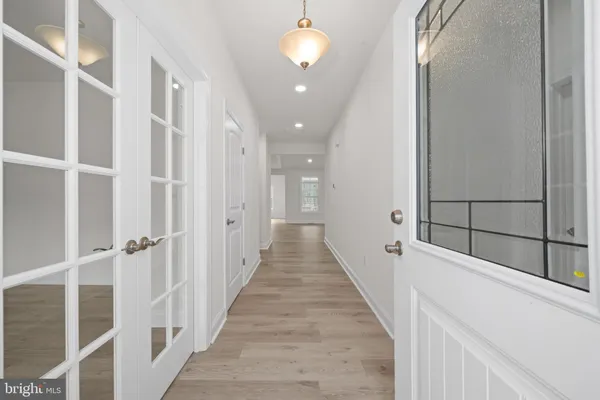 a view of a hallway with wooden floor and staircase