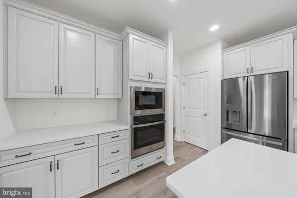 a kitchen with stainless steel appliances a refrigerator and cabinets