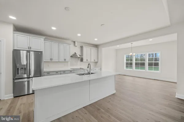 a large kitchen with stainless steel appliances granite countertop a refrigerator and a stove top oven