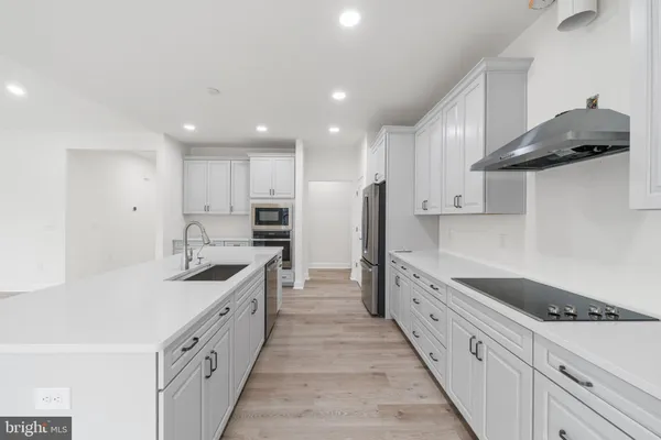a large kitchen with stainless steel appliances lots of counter space and a sink
