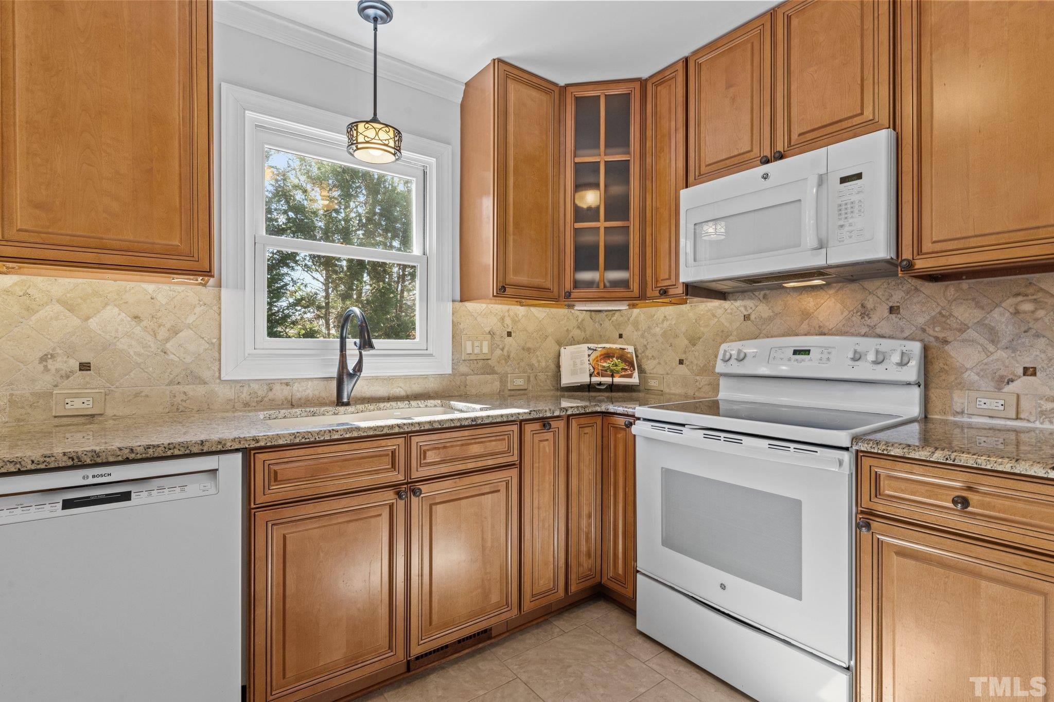 8325 Apple Orchard Way Raleigh, NC 27615 - Photo 17 of 54 a kitchen with granite countertop white cabinets stainless steel appliances and a sink