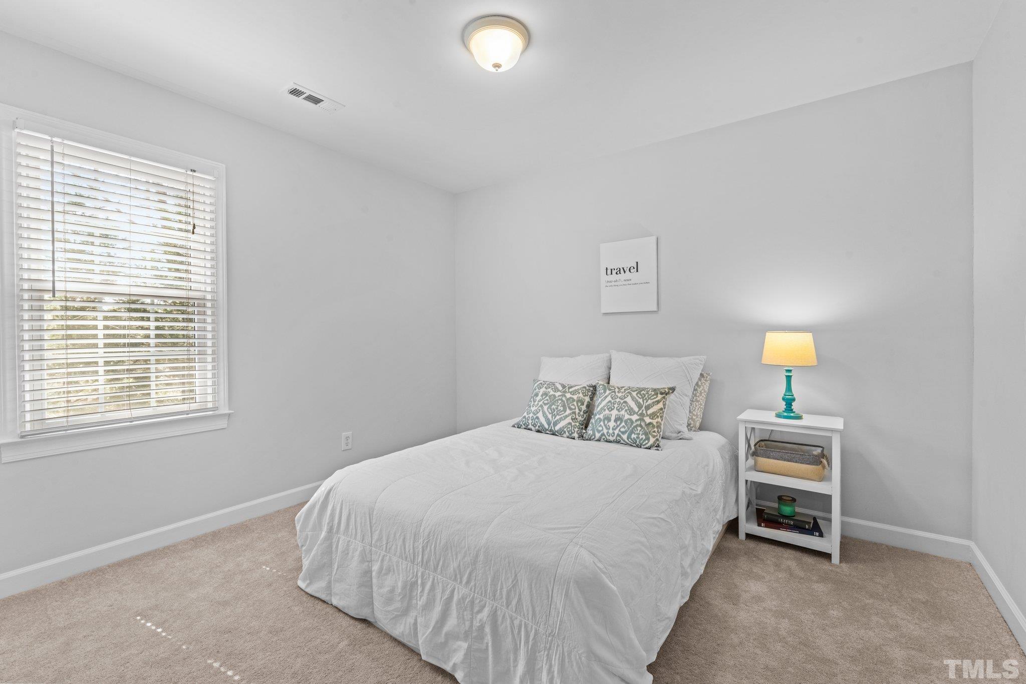 8325 Apple Orchard Way Raleigh, NC 27615 - Photo 26 of 54 a bedroom with a bed and a lamp on dresser