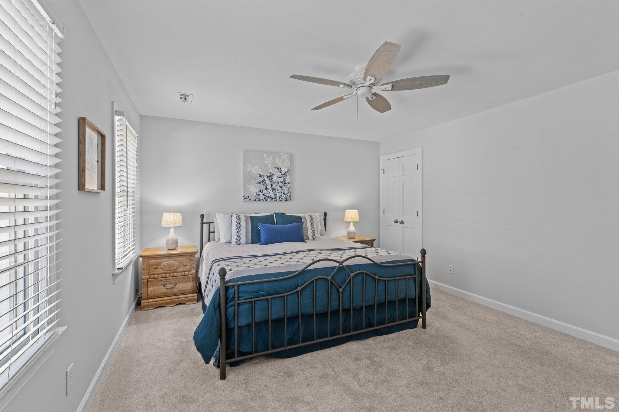 8325 Apple Orchard Way Raleigh, NC 27615 - Photo 30 of 54 a bedroom with a bed lamp and a window