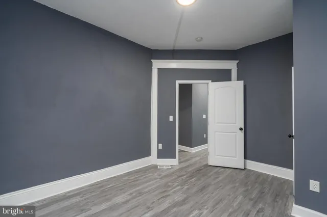 an empty room with wooden floor and closet