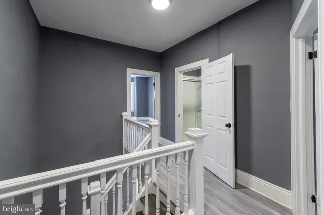 a view of a hallway with wooden floor and staircase