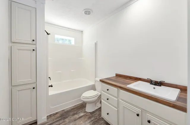 a bathroom with a granite countertop toilet a sink and a bathtub