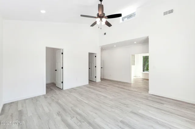 a view of an empty room with wooden floor