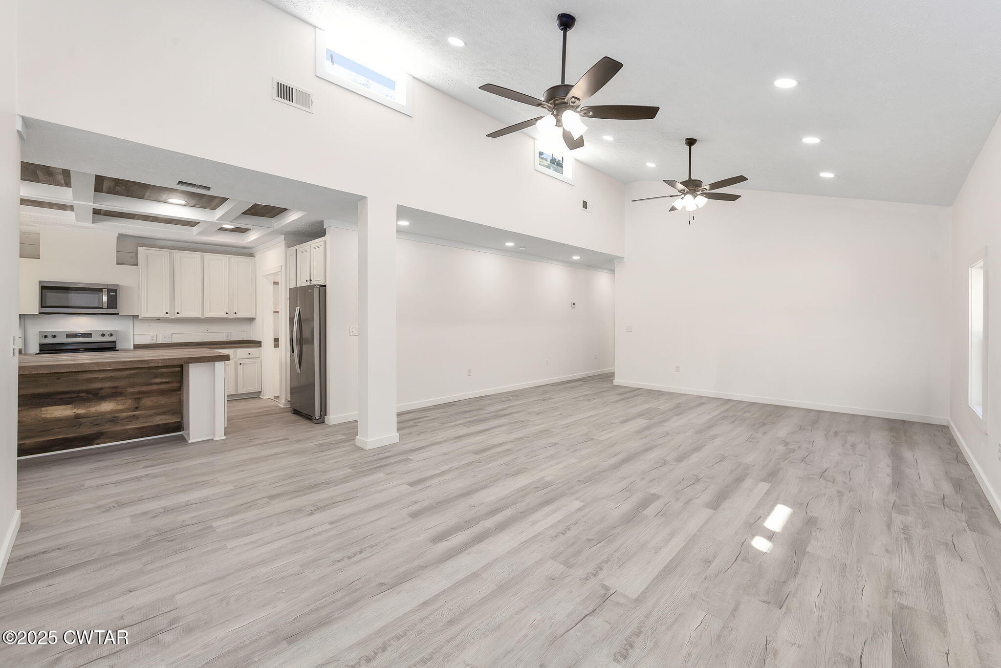 2885 Old Friendship Road Finger, TN 38334 - Photo 2 of 50 an empty room with wooden floor kitchen appliances and a ceiling fan