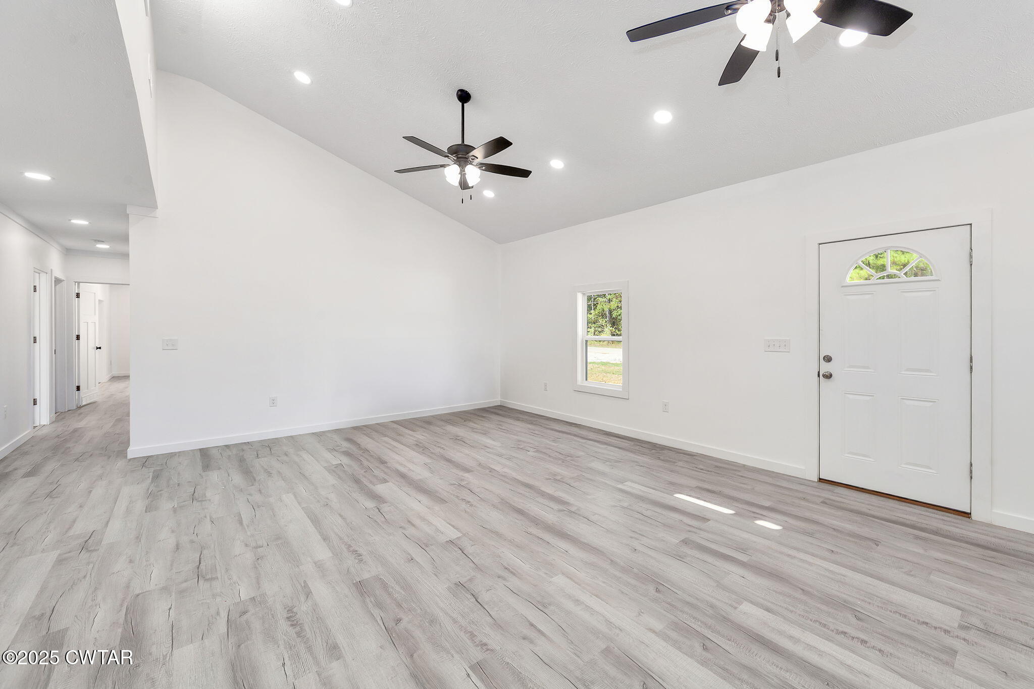 2885 Old Friendship Road Finger, TN 38334 - Photo 3 of 50 an empty room with wooden floor chandelier fan and windows