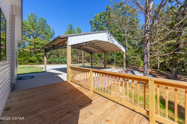a view of a patio with wooden floor next to a yard