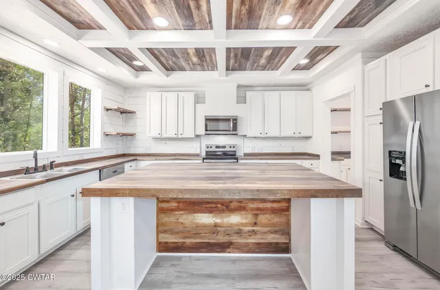 a kitchen with stainless steel appliances granite countertop a sink window and refrigerator