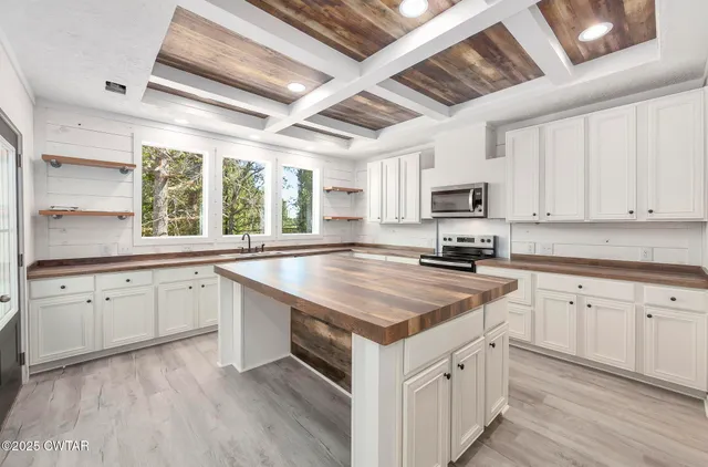 a kitchen with granite countertop a sink appliances cabinets and a counter top space