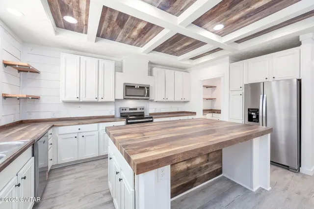 a kitchen with appliances a sink and cabinets