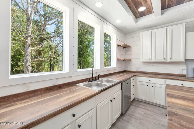 a kitchen with granite countertop white cabinets and a large window