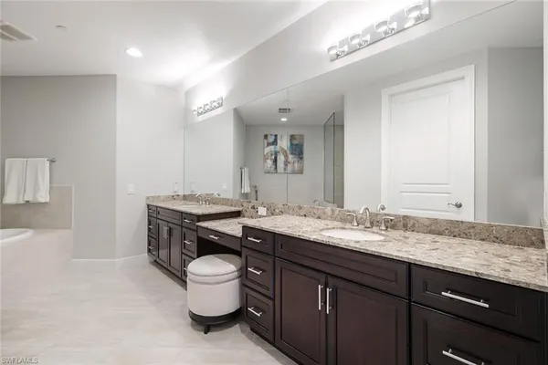 a bathroom with a granite countertop sink a toilet and a mirror