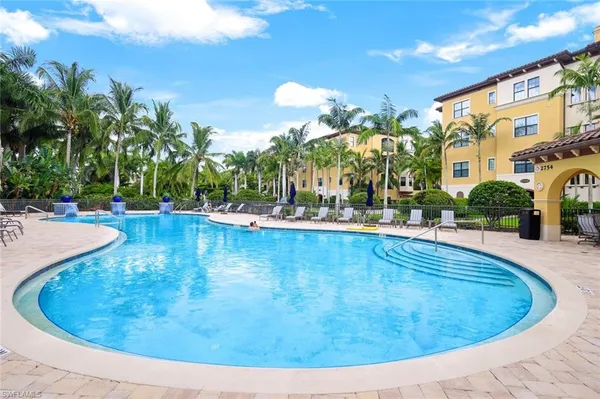 a view of a swimming pool with a lawn chairs and potted plants