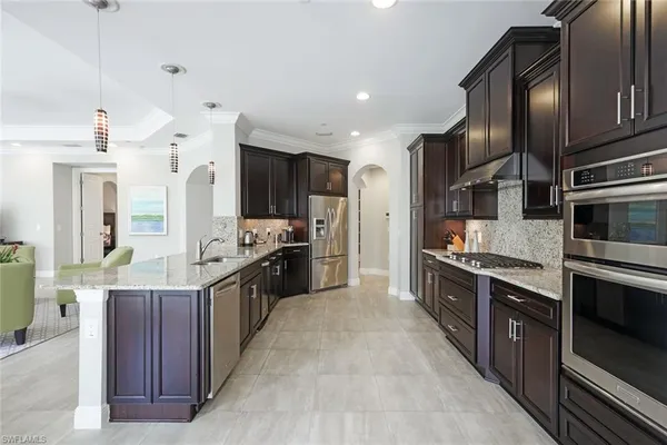 a large kitchen with stainless steel appliances wooden cabinets and a stove