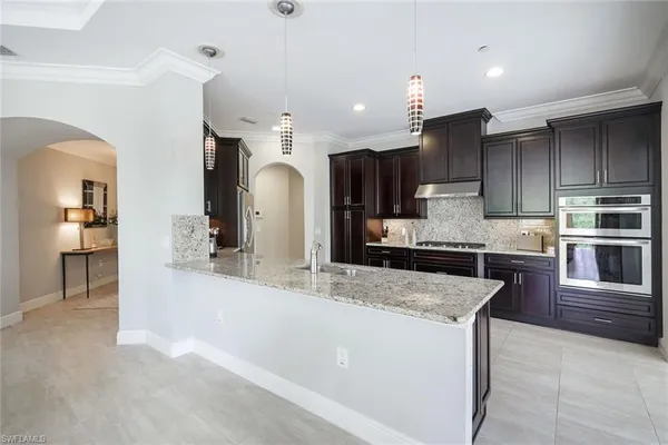 a large kitchen with kitchen island a sink stainless steel appliances and cabinets